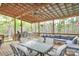 Spacious covered deck with a ceiling fan, grill, dining table and comfortable outdoor seating at 111 Painted Bunting Dr, Troutman, NC 28166