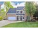 Charming two-story brick home featuring a well-manicured lawn and inviting front porch at 111 Painted Bunting Dr, Troutman, NC 28166