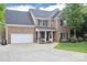 Brick home with a well-manicured lawn, a two-car garage, and charming front porch at 111 Painted Bunting Dr, Troutman, NC 28166
