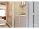 Bright laundry area featuring a white washer and dryer, and shelving for storage at 111 Painted Bunting Dr, Troutman, NC 28166