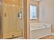 This bathroom features a glass shower, a soaking tub, and a window for natural light at 111 Painted Bunting Dr, Troutman, NC 28166