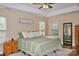 Bright bedroom with a tray ceiling, a plush bed, lots of natural light and a large mirror at 111 Painted Bunting Dr, Troutman, NC 28166
