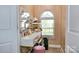 Walk-in closet featuring a vanity table, storage shelves, lighting, arched window and a pink ottoman at 111 Painted Bunting Dr, Troutman, NC 28166