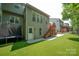 Back exterior with a deck, stairs, white door, lush green lawn, and attractive landscaping at 1125 Victoria Blake Ln, Belmont, NC 28012