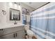 Bright bathroom with a single vanity, a large mirror, and a shower with blue striped curtain at 1125 Victoria Blake Ln, Belmont, NC 28012