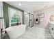 Bright bathroom featuring a large soaking tub beneath a window and a glass enclosed shower at 1125 Victoria Blake Ln, Belmont, NC 28012