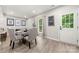 Bright dining area features a glass table with upholstered chairs and decor near a window and door at 1125 Victoria Blake Ln, Belmont, NC 28012