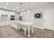 Bright kitchen with white cabinets, large island with seating, and stainless steel appliances at 1125 Victoria Blake Ln, Belmont, NC 28012