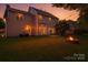 A backyard oasis offers a fire pit, grass, string lights and patio doors to home at 119 Tilton Dr, Mooresville, NC 28115