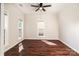 An empty room showcasing the wood flooring, two windows, neutral walls, and natural light at 119 Tilton Dr, Mooresville, NC 28115