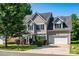 Charming two-story home with a well-manicured lawn, green shutters, and a two-car garage on a sunny day at 119 Tilton Dr, Mooresville, NC 28115