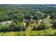 An aerial view highlighting a cozy home, bordered by mature trees, in a peaceful neighborhood with distant views at 1227 Breezewood Dr, Charlotte, NC 28262