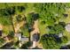 An aerial view showcasing a cozy home, bordered by mature trees, with an adjacent building on its own lot at 1227 Breezewood Dr, Charlotte, NC 28262