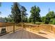 Backyard deck with a natural wood railing and a spacious view of the wooded yard at 1227 Breezewood Dr, Charlotte, NC 28262