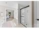 Elegant bathroom featuring a glass-enclosed shower, a soaking tub, and access to the main bedroom at 1227 Breezewood Dr, Charlotte, NC 28262
