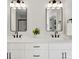 A bathroom features dual sinks with modern fixtures, illuminated mirrors, and a potted green plant at 1227 Breezewood Dr, Charlotte, NC 28262
