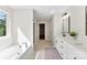 Bright bathroom showcasing a soaking tub, double vanity, and a walk-in shower with modern fixtures at 1227 Breezewood Dr, Charlotte, NC 28262
