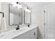 Bright bathroom featuring a double vanity with framed mirrors, white cabinets, and matte black hardware at 1227 Breezewood Dr, Charlotte, NC 28262