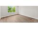 Empty bedroom showcasing new wood-look flooring and a large window with a wooded view at 1227 Breezewood Dr, Charlotte, NC 28262