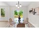 Dining area features a glass table and chairs, light fixture, and sliding glass doors leading to a deck at 1227 Breezewood Dr, Charlotte, NC 28262
