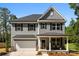 Charming two-story home with gray siding, black shutters, covered front porch, and attached two-car garage at 1227 Breezewood Dr, Charlotte, NC 28262