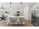 Open kitchen with island, stainless appliances, pendant lights and white cabinets with eat in dining area at 1227 Breezewood Dr, Charlotte, NC 28262
