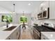Modern kitchen featuring white cabinets, stainless steel appliances, and a spacious island with quartz countertops at 1227 Breezewood Dr, Charlotte, NC 28262