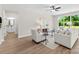 Comfortable living room with lots of natural light, neutral walls, light hardwood floors, and a ceiling fan at 1227 Breezewood Dr, Charlotte, NC 28262