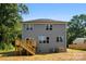 The home's rear exterior features a small deck, gray siding and multiple windows overlooking the backyard at 1227 Breezewood Dr, Charlotte, NC 28262