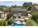 Aerial view of a backyard with a pool, patio area with pergola, solar panels, and mature trees at 125 Snow Fountain Ln, Mooresville, NC 28115