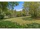 A spacious backyard featuring a large grassy area surrounded by mature trees and a metal fence at 125 Snow Fountain Ln, Mooresville, NC 28115