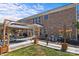 Brick home featuring a covered patio area with dining, a hammock, lush landscaping, and an outdoor utility area at 125 Snow Fountain Ln, Mooresville, NC 28115