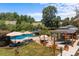 A full shot of a private backyard oasis featuring a pool, covered patio area, lush landscaping, and outdoor seating at 125 Snow Fountain Ln, Mooresville, NC 28115