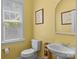 Charming half bath with vintage style features bright yellow paint and natural light at 125 Snow Fountain Ln, Mooresville, NC 28115