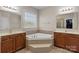 Elegant bathroom has a tiled tub, and sinks and vanity with wooden cabinets at 125 Snow Fountain Ln, Mooresville, NC 28115