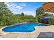 Landscaped pool area featuring blue pool water, stone accents, and nearby shady umbrella at 125 Snow Fountain Ln, Mooresville, NC 28115