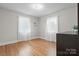 Minimalist bedroom with hardwood floors, two windows with natural light and neutral gray walls at 151 Third Creek Rd, Statesville, NC 28677