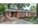 Inviting brick home featuring mature trees and a ramp leading to the front porch at 151 Third Creek Rd, Statesville, NC 28677