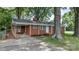 Quaint brick home featuring mature trees and a ramp leading to the front porch at 151 Third Creek Rd, Statesville, NC 28677