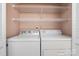 Bright laundry room featuring a washer and dryer with convenient shelving at 151 Third Creek Rd, Statesville, NC 28677