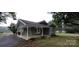 Side view of a quaint single-story home featuring a covered porch and landscaped yard at 1521 N Piedmont Ave, Kings Mountain, NC 28086