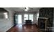 Cozy living room with stone fireplace, wood floors, and ample natural light through the front door and windows at 1521 N Piedmont Ave, Kings Mountain, NC 28086
