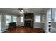 Spacious living room featuring hardwood floors, multiple windows, and a stone fireplace at 1521 N Piedmont Ave, Kings Mountain, NC 28086