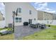 Spacious backyard with a concrete patio, modern outdoor furniture, and a basketball hoop for entertainment at 1624 Savory Ln, Charlotte, NC 28216