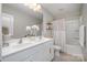 Bright bathroom featuring a double sink vanity, large mirror, and a combined shower and tub with a white shower curtain at 1624 Savory Ln, Charlotte, NC 28216