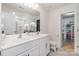 Bright bathroom with double vanity, a large mirror, and a well-organized closet at 1624 Savory Ln, Charlotte, NC 28216