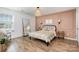 Bright bedroom featuring wood floors, a full length mirror and soft textures, creating a cozy and inviting retreat at 1624 Savory Ln, Charlotte, NC 28216