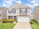 Charming two-story home with stone accents, a well-manicured lawn, and a two-car garage at 1624 Savory Ln, Charlotte, NC 28216