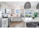 Modern kitchen boasts stainless steel appliances, white countertops, and backyard access to a delightful outdoor living space at 1624 Savory Ln, Charlotte, NC 28216