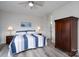 Bedroom featuring a comfortable bed with blue and white striped bedding, ceiling fan and closet at 18511 Harborside Dr, Cornelius, NC 28031
